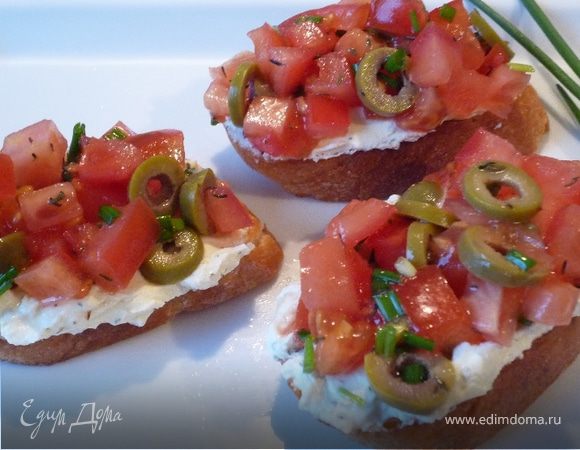 На сковороде разогреть оставшееся оливковое масло, добавить давленый чеснок и подрумянить кусочки багета. Затем выложить на багет сливочный сыр, сверху овощи. Сразу же подавать к столу. Приятного аппетита! 