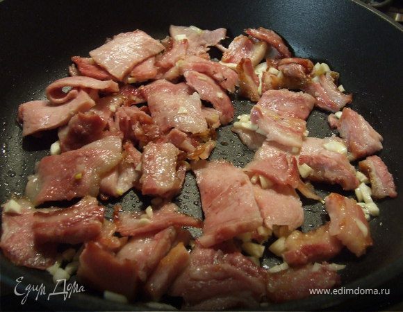 Бекон нарезать тонкими ломтиками, чеснок мелко нарезать и обжарить.