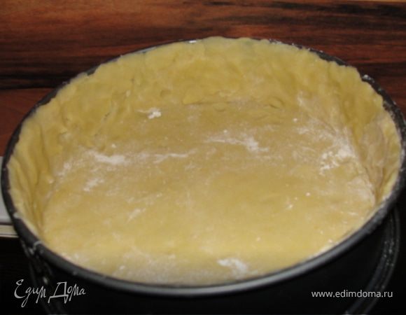 Форму смазать маслом или маргарином и обсыпать сухарями. Раскатать тесто, уложить в форму и сформировать края в 3 см.