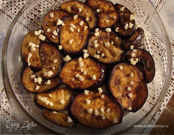 Готовые баклажаны выкладываем на блюдо в один слой и посыпаем рубленым чесноком.