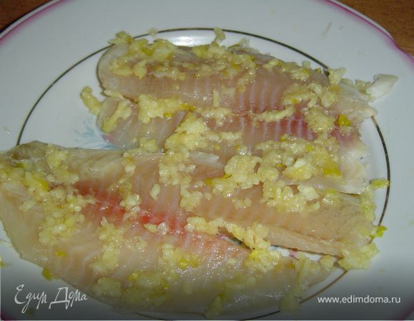 Чеснок очищаем и пропускаем через чеснокодавку.Наносим чеснок на рыбное филе, предварительно посолив его. Оставляем филе с чесноком на два часа.