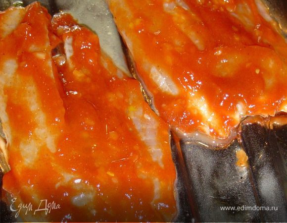 Потом обмазываем их кетчупом и выкладываем на противень, смазанный растительным маслом.