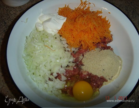 Лук мелко покрошить. Морковь натереть на мелкой терке. В фарш положить панировочные сухари, лук, морковь, 1 яйцо и 2-3- ложки сметаны.