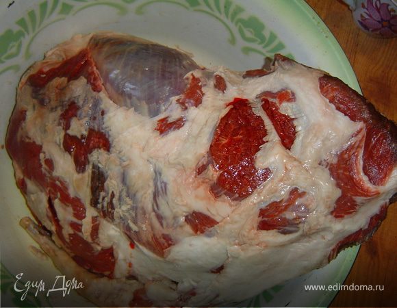 Берем баранью ногу, моем, обрезаем плеву.
Нашпиговываем ее чесноком и морковью.