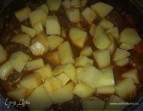 Лук поджарить на растительном масле, добавить к луку сухую паприку и тушить минут 10 на маленьком огне, помешивая. Выложить мясо к луку, хорошо перемешать, добавить воды грамм 100, и тушить минут 40-50 под закрытой крышкой. Затем  морковь и корень петрушки опустить к мясу, перемешать и накрыть крышкой. Через 20 мин положить сладкий перец и острый перчик, мелко нарезанный, и помидоры, порезанные кубиками (зимой я не использую свежие помидоры – нет должного результата, а беру порезанные кубиками марки Pomito). Все хорошо перемешать и накрыть крышкой и тушить мин.15-20.Почистить картофель и нарезать его кубиками средней величины. Опустить в казан, добавить при необходимости воды (должен быть заполнен до верху),посолить и накрыть крышкой. Продолжать готовить на слабом огне до тех пор, пока не будет готов картофель. 