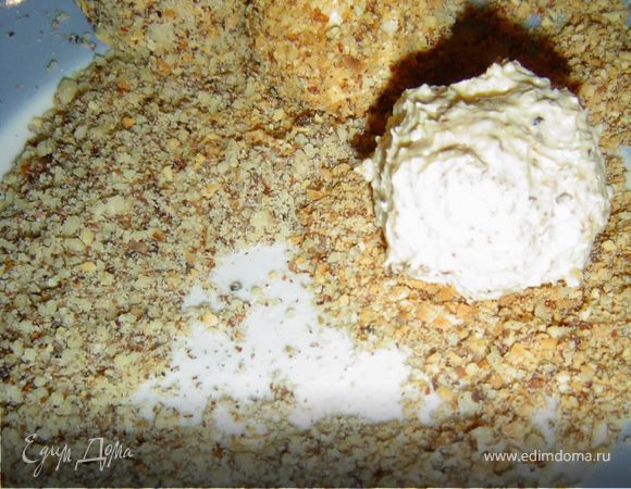 Тщательно перемешиваем с помощью блендера, формируем из этой массы шарики. В центре шариков делаем углубления и заполняем их красной икрой. Готовые шарики обваливаем в сыре, грецких и миндальных орехах. 