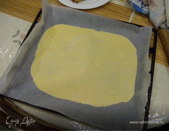 4. Растопить 100 г масла для обмазки. Уложить 1 слой теста на бумагу. (можно переносить с помощью скалки, предварительно намотав на нее тесто). Если блинчик маловат - его можно потянуть руками в стороны