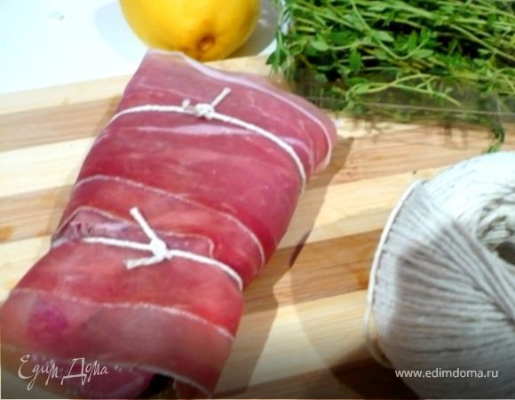 Завернуть мясо в прошутто рулетом. Перевязать кулинарной ниткой в нескольких местах. Положить в форму. Добавить 2 целых зубчика чеснока и запекать в разогретой до 230 С:
- 25-30 минут - с кровью
- 40 минут - средняя прожаренность 
- 50 минут - хорошо прожаренное
На "полпути" добавить вино. 
Готовое мясо выложить на тарелку. Соус из под мяса вернуть в сковороду из под грибов проварить пару минут. Полить этим соусом мясо или подать его отдельно в соуснике.
