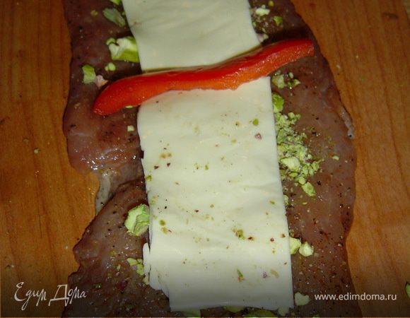 Пластинки сыра делим на две части и укладываем на фисташки.На сыр кладем кусочек сладкого перца