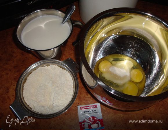 В миску, в которой будем замешивать тесто, разбиваем 2 больших или 3 поменьше яйца (я почти всегда беру 3 яйца), добавляем соль, сахар. Отмеряем немного муки в другую миску (маленькую, около 1 или 1,5 стаканов) и высыпаем туда дрожжи, тщательно перемешиваем.
Горячее молоко доливаем холодной водой до объема около 950 миллилитров, так, чтобы температура молока была тепленькой, но не горячей - чтобы не заварить дрожжи.