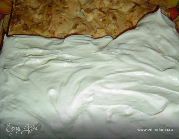 Когда коржи и крем готовы, приступаем к сборке торта. Выложим весь крем на один корж и распределим его по всей поверхности коржа. Сверху накрываем вторым коржом и отправляем в холодильник на три – четыре часа.