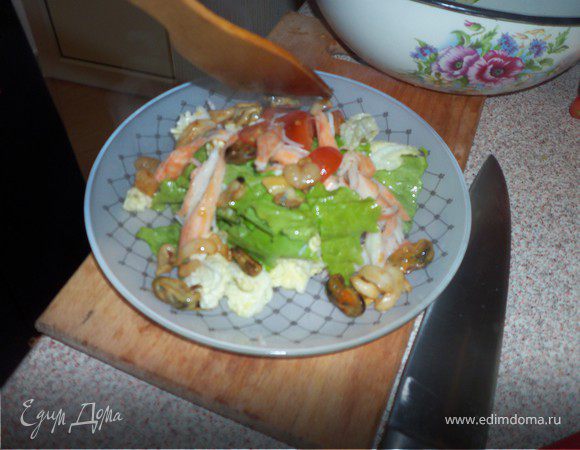 Выложить салат на блюдо и ввести в него горячие морепродукты