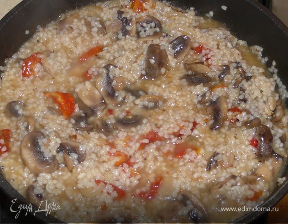 Протушить лук, добавить чеснок и грибы, пару минут потушить, добавить рис, перемешать и залить вино. Подождать, пока выпарится. Положить помидоры и подлить бульона, подождать, пока рис впитает жидкость и еще пару раз по чуть-чуть влить бульон.
Посыпать петрушкой, вмешать шпинат и пармезан. Пару минут прогреть. Подавать
