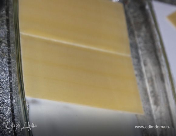 В форму для запекания выложить листы лазаньи,предварительно смазав дно соусом "Бешамель", некоторые фирмы предлагают листы лазаньи отварить, некоторые - использовать сухие листы.