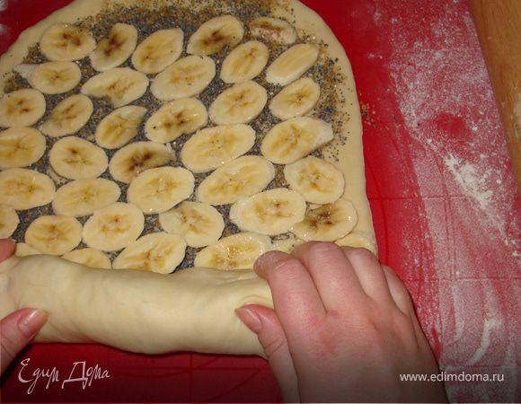 Зацепив короткий край раскатанного теста начинаем сворачивать рулет.