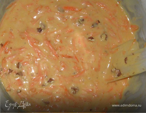 Влейте смесь в миску с мукой. Хорошо перемешайте все деревянной ложкой. Добавьте морковь и орехи. Вновь перемешайте.