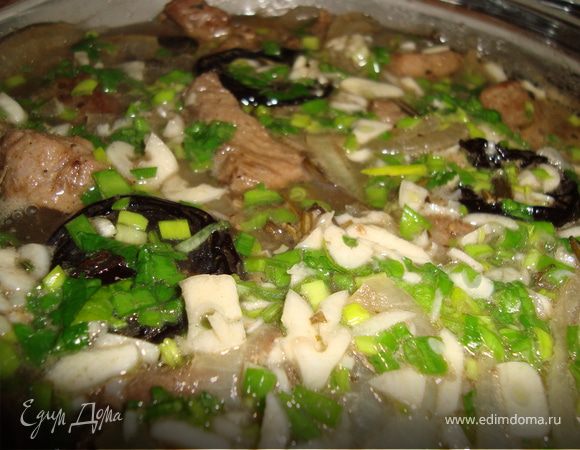 Чеснок и зелень мелко нарубить, добавить к свинине с черносливом и тушить еще 15 минут.