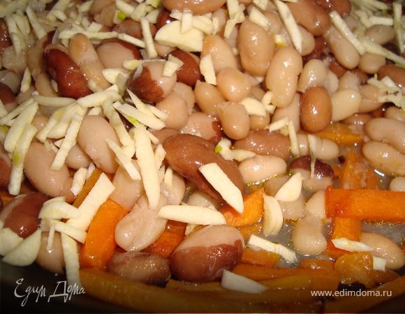 Слить с Фасоли воду и отправить к моркови. Мелко нарезаем чеснок и добавляем в сковороду. Все вместе обжариваем