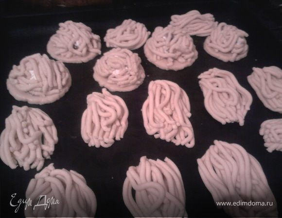 Класть кусочки теста в мясорубку и выкрученное порционно раскладывать не противне.
В моем варианте - сделать шарик и теста, приплюснуть, чтобы получился кружок, выложить начинку на кружок, а сверху начинки хаотично выложить выкрученные полосочки теста.  