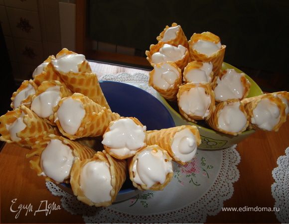 с помощью шприца или пакета начинить конусы кремом, дать постоять в холоде