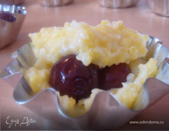 Далее начинаем распределять поленту по формочкам. В серединку выкладываем по 3 вишенки и по мармеладке-чередуя формочки. Прикрываем это дело полентой и ровняем.