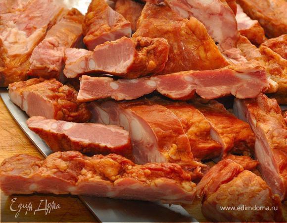 Копченые свиные хрящи нарезать небольшими кусочками. Полоски бекона обжарить на раскаленной сковороде без масла до румяного состояния и откинуть на время. В эту же сковородку выложить хрящи в оставшийся от бекона жир, добавить половник отвара из кастрюли с горохом и тушить на среднем огне 30 минут.