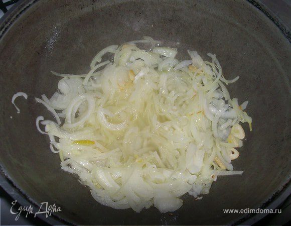 Лук шинкуем тонкими полукольцами и жарим в казане до золотистого цвета, добавляем приправу и жарим ещё 3 минуты.