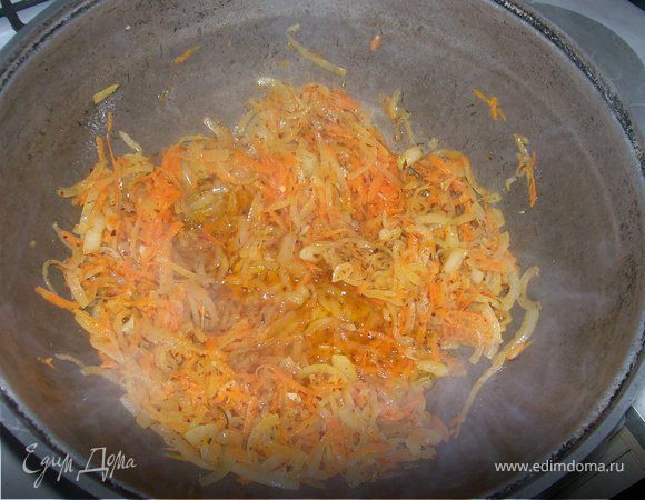 Добавляем к луку на тертую на крупной терке морковь и жарим 10 - 15 минут на среднем огне.