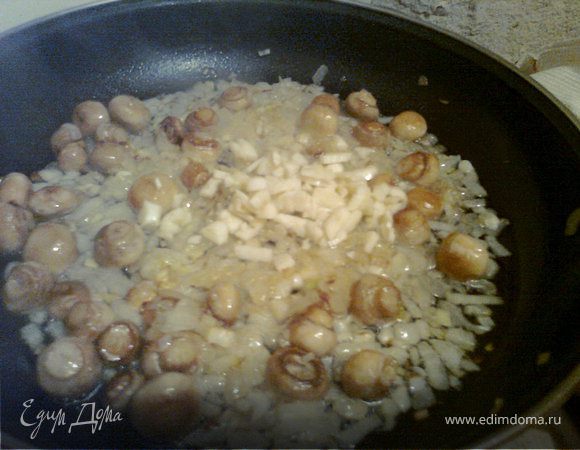 Когда лук и грибы почти готовы, добавляем мелко нарезанный чеснок и отставляем сковороду с огня.