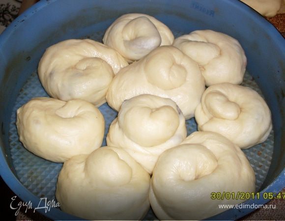 Уложите спирали рядом, оставляя свободное место, в форму. Дайте подняться 5–10 минут, смажьте сладкой водой.