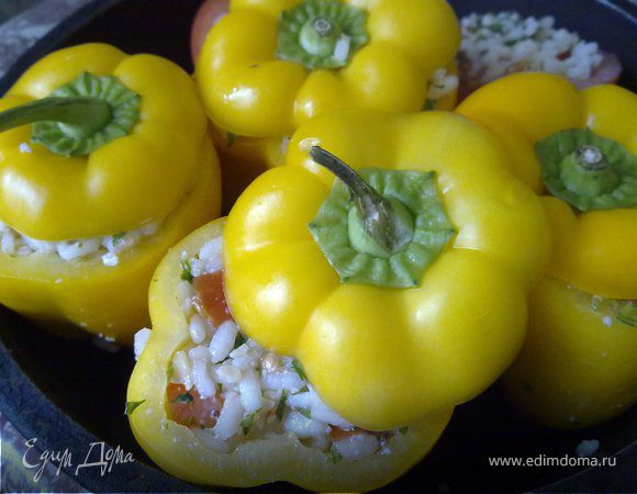 Отварить рис в солёной воде аль денте, добавить оливковое масло и остудить. Смешать рис с половиной нарезанных помидор, половиной рубленой петрушки, слегка взбитыми желтками и сыром. Всё хорошо перемешать. И начинить этим перец. Закрыть крышечкой.Начинять и складывать в форму. В форму нужно налить оливковое масло, помидоры (вторую часть), петрушку (вторую часть) и рубленый чеснок. Каждый перец смазать оливковым маслом. Посыпатье солью и перцем. Закрыть фольгой форму и запекать при температуре 190°С минут40. Затем снимите фольгу, и запекайте ещё 15 минут при температуре 200°С.