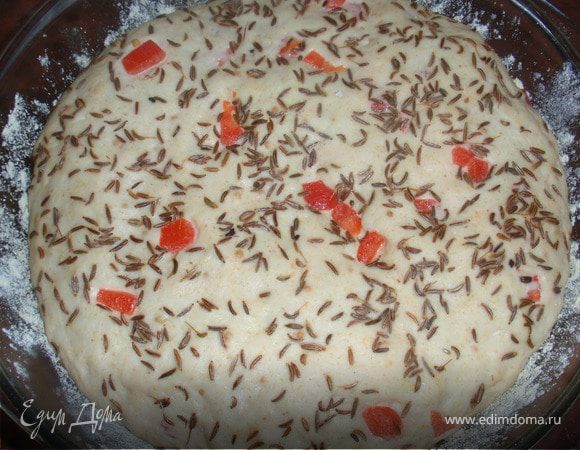 Вмешать порезанный на мелкие кубики болгарский перец. Выложить тесто в форму смазанную оливковым маслом и посыпанную кукурузной мукой. Смазать будущий хлеб оливковым маслом и щедро посыпать тмином, немного вдавив его.