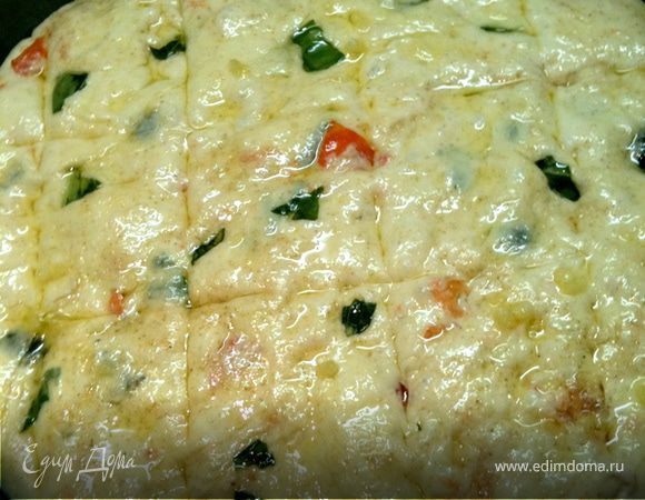 Залить дрожжи теплым кефиром, добавить пол стакана  муки грубого помола, и пол стакана гречневой муки, стакан обычной, томаты, базилик и оливки. Замесить опару, оставить минут на 20—40 в теплом месте. В оливковое масло добавить чеснок. Перемешать. Затем добавить в тесто оставшуюся муку, оливковое масло с чесноком и замесить тесто. Выложить в круглую форму. Оставить минут 30—40. , затем сделать надрезы и промазать оливковым маслом с чесноком. 