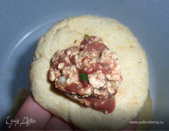 Разделить тесто примерно на 10 частей. Чуть приплюснуть, на середину каждого положить начинку. Сформировать шарики.