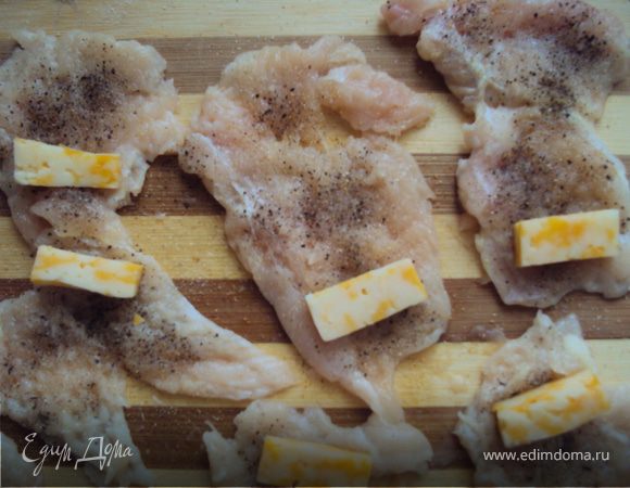 Отбитые кусочки куриного филе с одной стороны натираем солью, перцем, чесноком. 