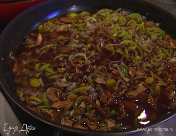 Добавить чечевицу, перемешать, влить воду из-под грибов, овощной бульон и красное вино и на медленном огне довести чечевицу до готовности.  