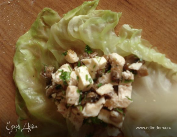 Выкладываем начинку на лист капусты, добавляем немного сметаны и заворачиваем конвертиком.