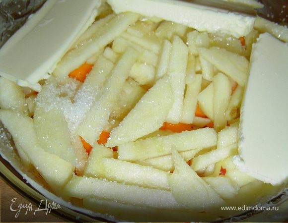 Сверху кладем очищенные и мелко нарезанные яблоки, так же посыпаем сахаром, вливаем воду, кладем сливочное масло и отправляем в духовку.
