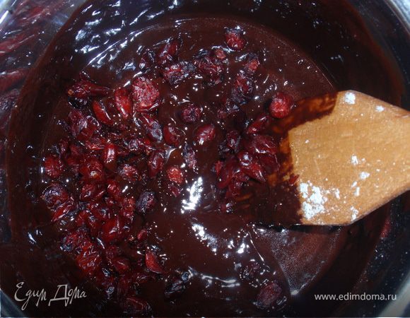 В остывшую шоколадную массу вмешать яйца, сахар, муку и клюкву. Выложить будущий брауни в форму, предварительно застеленной бумагой.