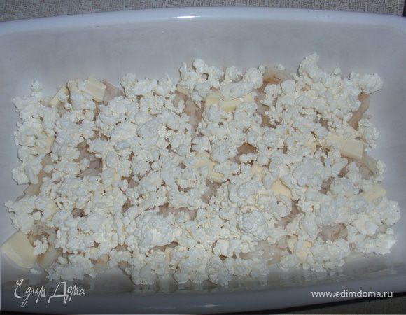 В форму для выпечки мелко порвать рыбу. Следующий слой - сливочное масло. Затем выкладываем творог.