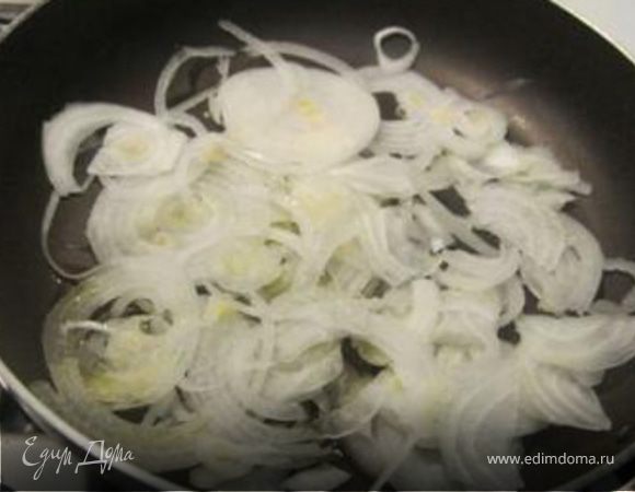 Лук нарезать полукольцами и обжарить на медленном огне в течение 10 мин.