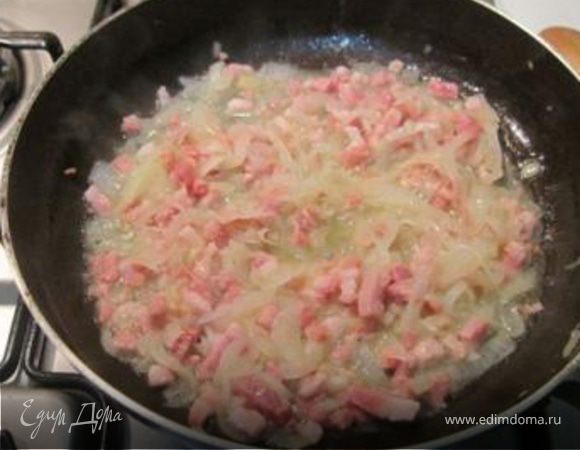 Когда лук смягчится, добавить нарезанный кубиками бекон и жарить пока бекон не подрумянится.