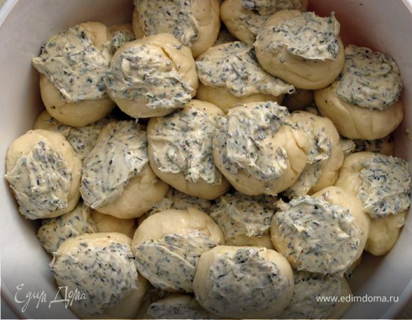 Каждый шарик намазать маслом с травами и выложить в смазанную оливковым маслом  стеклянную форму диаметром 15 см. (Ни в коем случае не берите разъемную форму, или застилайте ее полностью пергаментной бумагой, иначе масло может вытечь из формы). Шарики не должны примыкать слишком плотно друг к другу. Дать тесту подрасти в течение 30 мин. Выпекать 35 мин. при 180*С до золотистого цвета. Готовый хлеб сбрызнуть водой и накрыть полотенцем.  Когда немного остынет, можно употреблять. Приятного аппетита!

