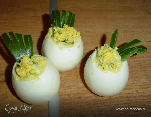 Отвариваем яйца, отцеживаем консервированный зеленый горошек.Яйца очищаем и отрезаем верхушки. Аккуратно вынимаем желтки, измельчаем их, сыр натираем на терке, горох пропускаем через мясорубку. Все перемешиваем и заправляем смесью майонеза и сметаны (50 на 50), солим, перчим по вкусу. Этой заправкой начиняем яйца. Из зеленого сладкого перца вырезаем "пену".