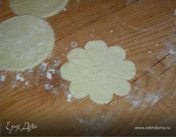 Раскатываем тесто, стаканом вырезаем круги и делим их на сегменты с помощью линейки.Закругляем каждый из сегментов. В результате получаем форму цветка.