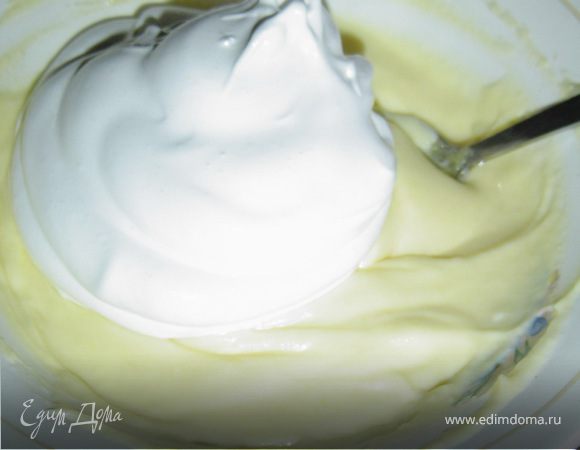 Белок взбиваем с оставшимся сахаром в крепкую пену, добавляем к крему, осторожно перемешиваем.
Белый шоколад (50 г) натираем на мелкой терке и добавляем в крем. Также натираем на терке цедру лимона и подмешиваем в крем.