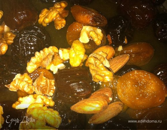 На сковородку отправляем наши сухофрукты и орехи, заливаем их водой, закрываем крышкои и пропариваем таким образом. Затем добавляем ложку мёда и кусок сливочного масла, закрываем снова крышкой и готовим еще минут 10. 