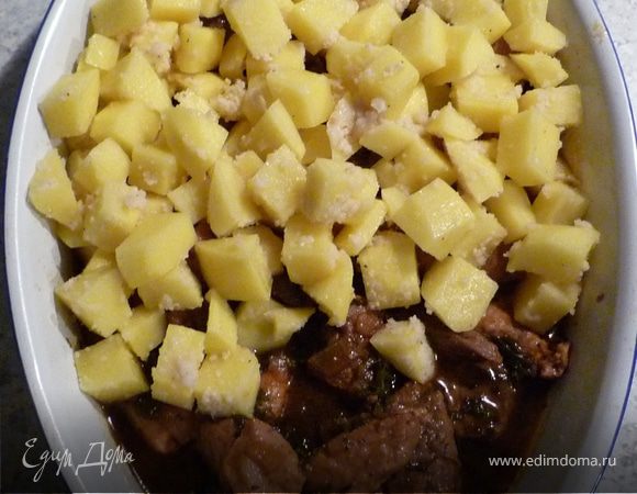 Гуляш выложить в форму для запекания, сверху - картофель и запекать 20 мин. Посыпать хлопьями сливочного масла и еще запечь в течение 10 мин. 