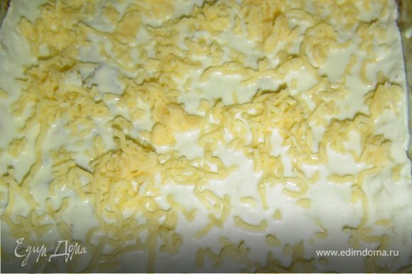 Лист лаваша окуните в подготовленную смесь из сметаны, молока, яиц и специй и положите на противень. Сыр натрите на мелкой терке и посыпьте лаваш.