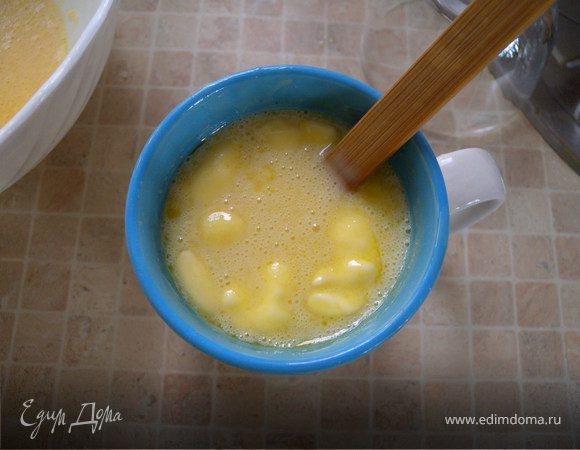 Сгущенку (из холодильника) перелить в чашку и поставить в микроволновку на 2 минуты (если не с холодильника - на 1 минуту), чтобы она стала теплой (около 40 С) и очень жидкой. Если это не сделать - тесто будет густое. Растопить в ней сливочное масло. 